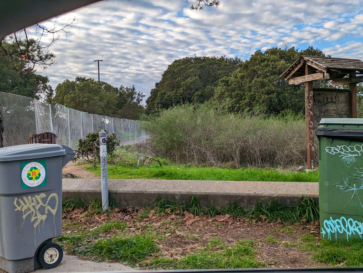 Entrance path is on the left by the fence.