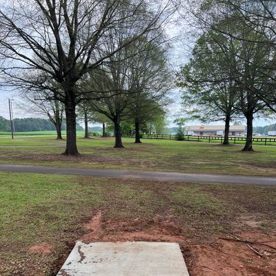 Hole 7 has a tree lined fairway that dog legs left to a 15’ peninsula green wrapped by OB path.
