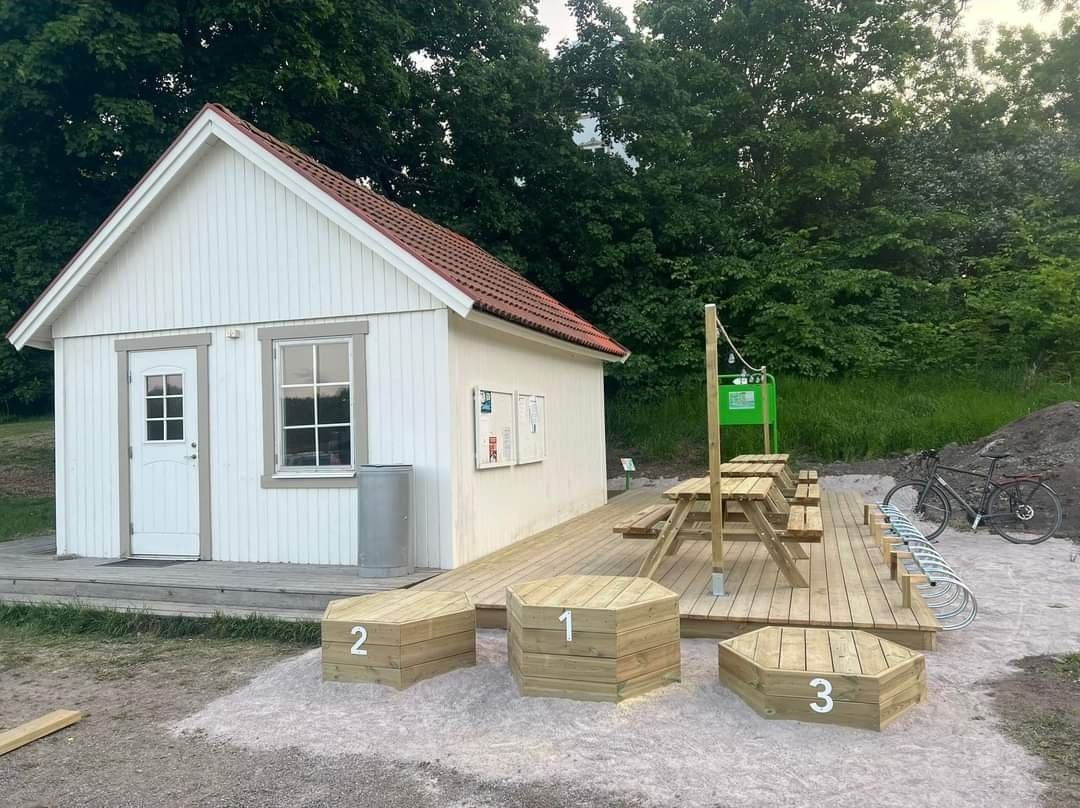 Nya tralldäcket med sittbänkar, cykelställ och ett tillhörande podie vid klubbstugan, Juni -23.