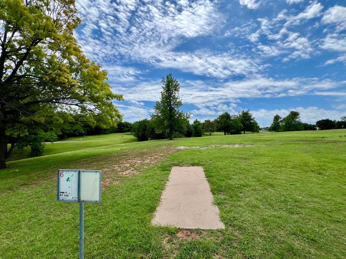 Hole 6. 450 ft par 4. Basket is on the opposite side of the creek and trees.