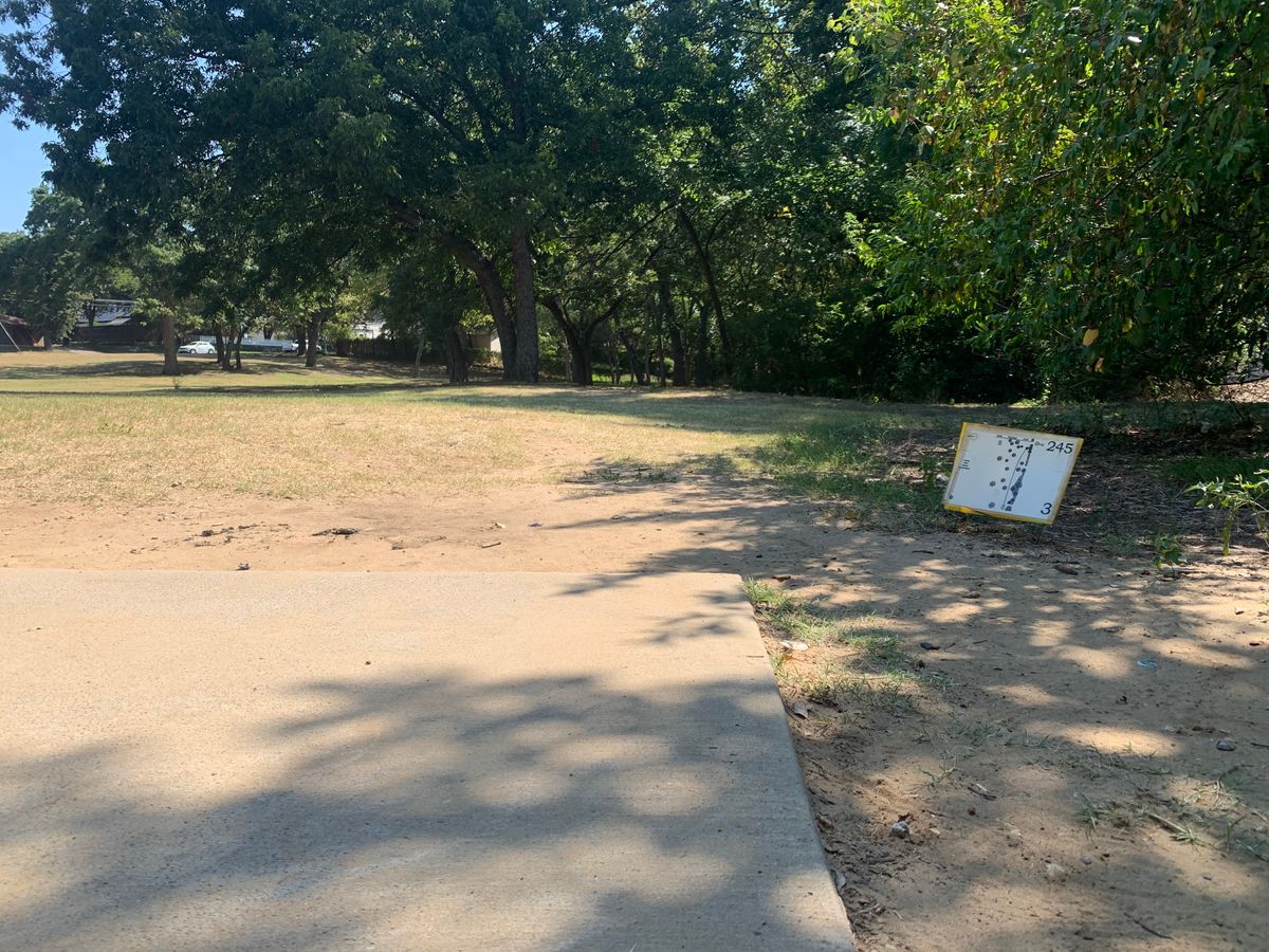 Hole 3, short hole, signage on the ground to the right of the tee pad.