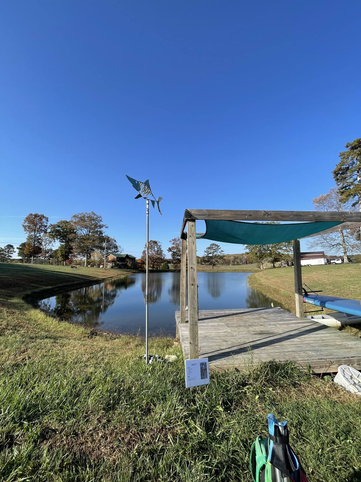 Hole 5 tee pad, water carry, basket over the edge of the backside bank. (Hole 9 in 2024)