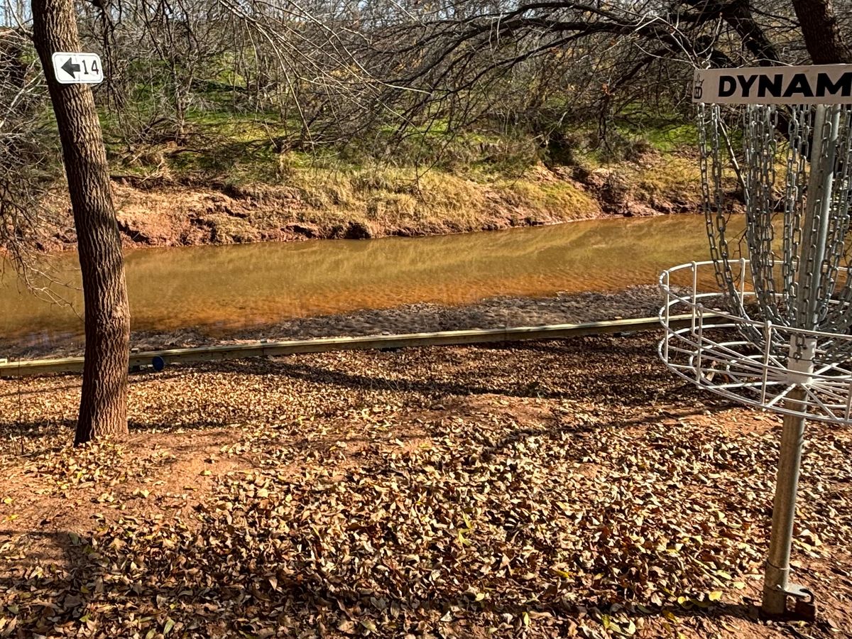 Hole 13 drop off behind basket.  Rail next to river to stop roll aways.