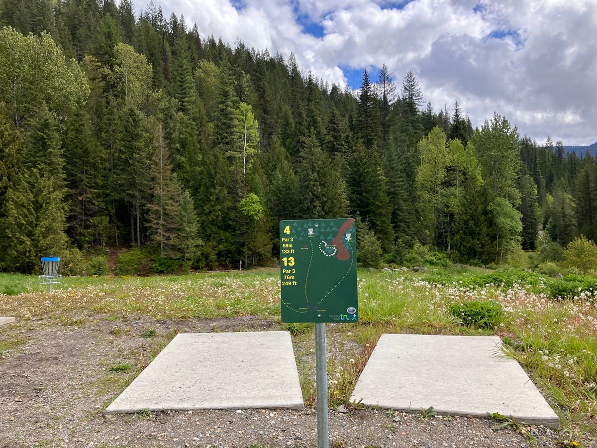 Showing hole 4 and hole  13  tee pads and sign with Basket for hole 3 in the background