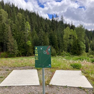 Showing hole 4 and hole  13  tee pads and sign with Basket for hole 3 in the background