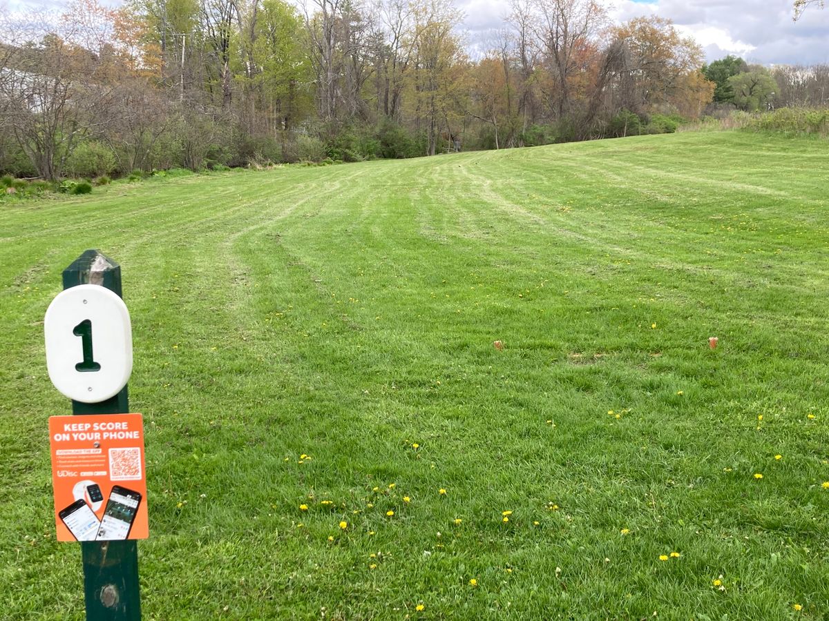 Red Tee Pad #1 lookin towards the basket

Fishkill Creek runs down the left side of the fairway, water is OUT OF BOUNDS