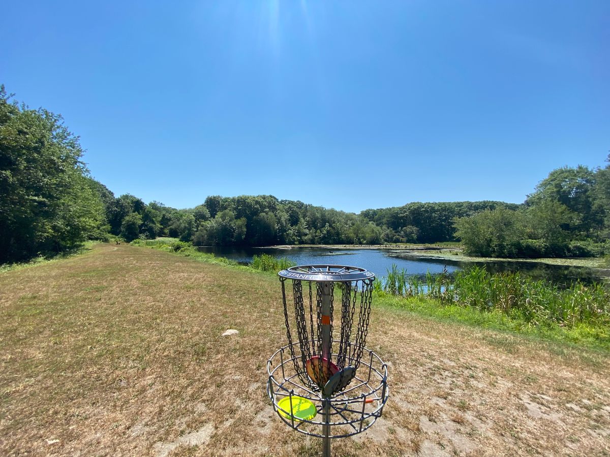 View from Hole 14’s basket looking back at the tee pad and lake.