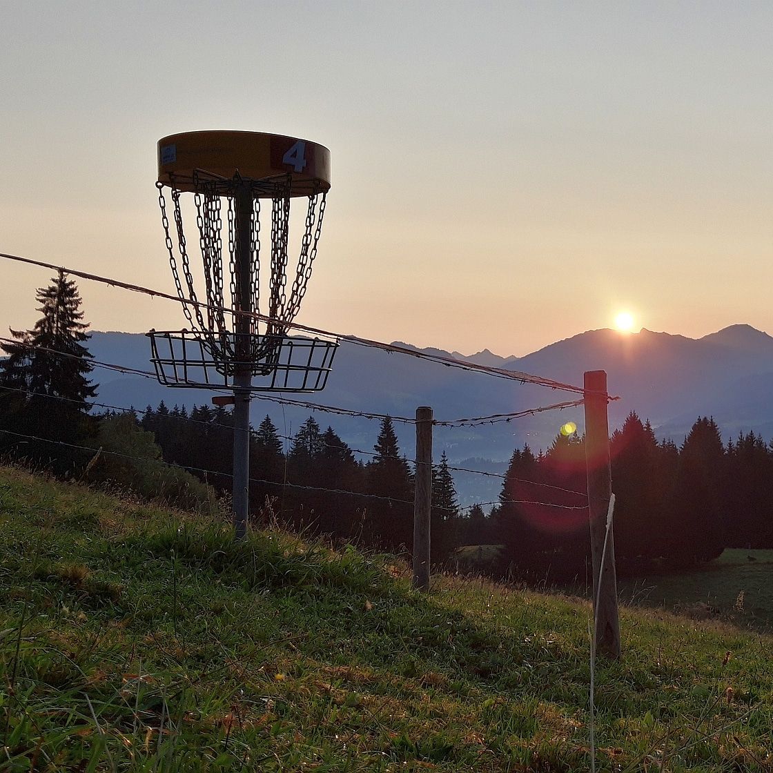 Sunrise at Disc Golf Allgaeu. Baskets are fenced off when the cows come.