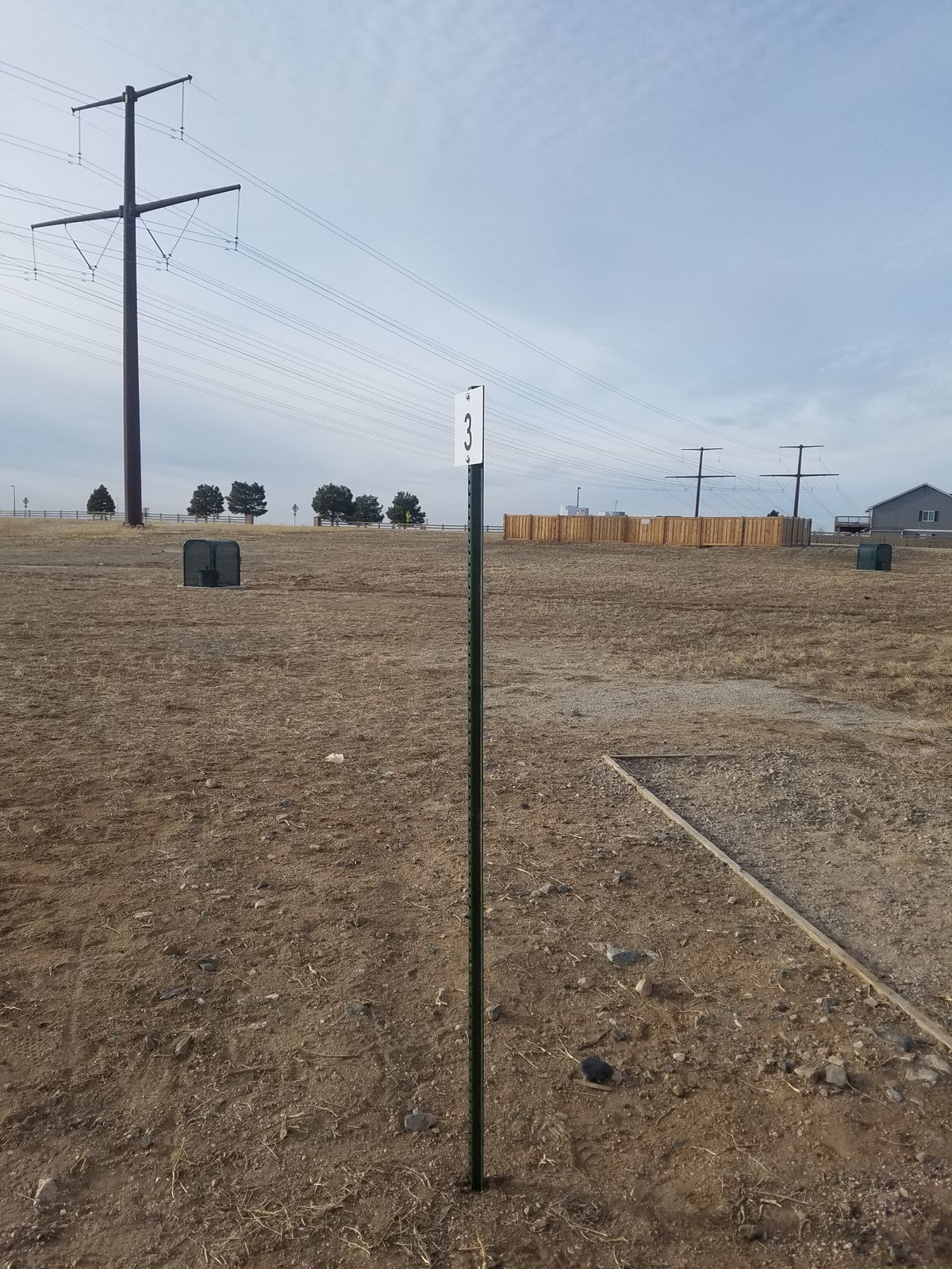 Hole #1, Tee box is up to the right of the basketball court & basket is just past the courts, small dogleg right.