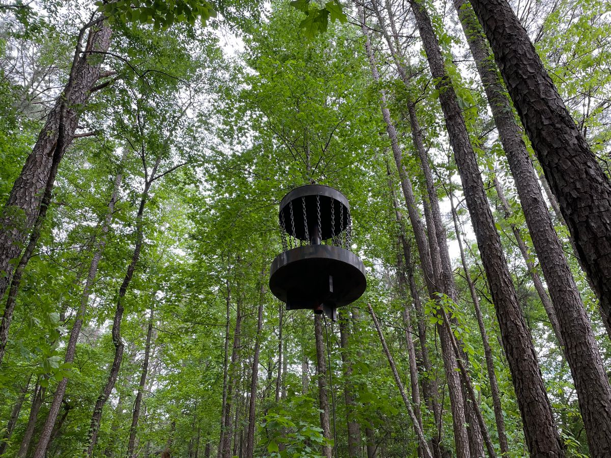 Hanging basket. Retrieve discs by pulling cable uphill. Basket rolls on a pulley.