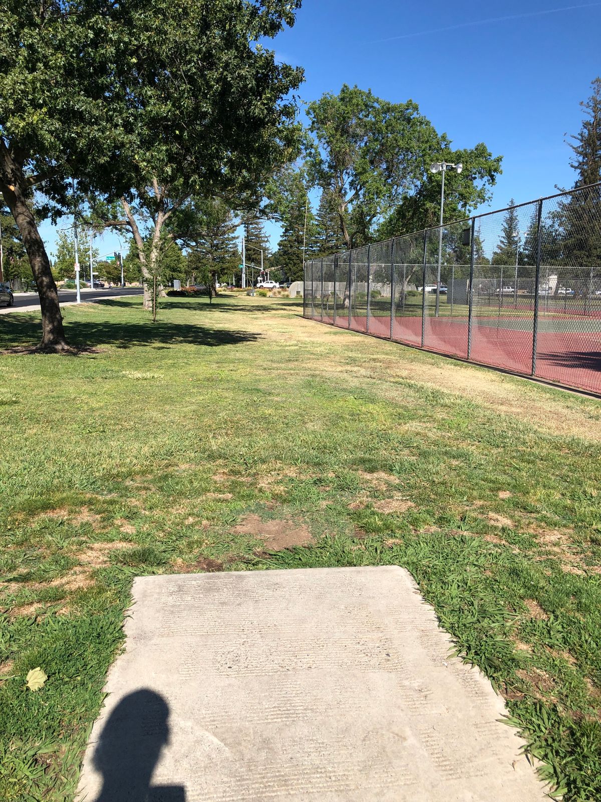 Hole 1 tee pad. Get the disc around the edge of the chain link fence.