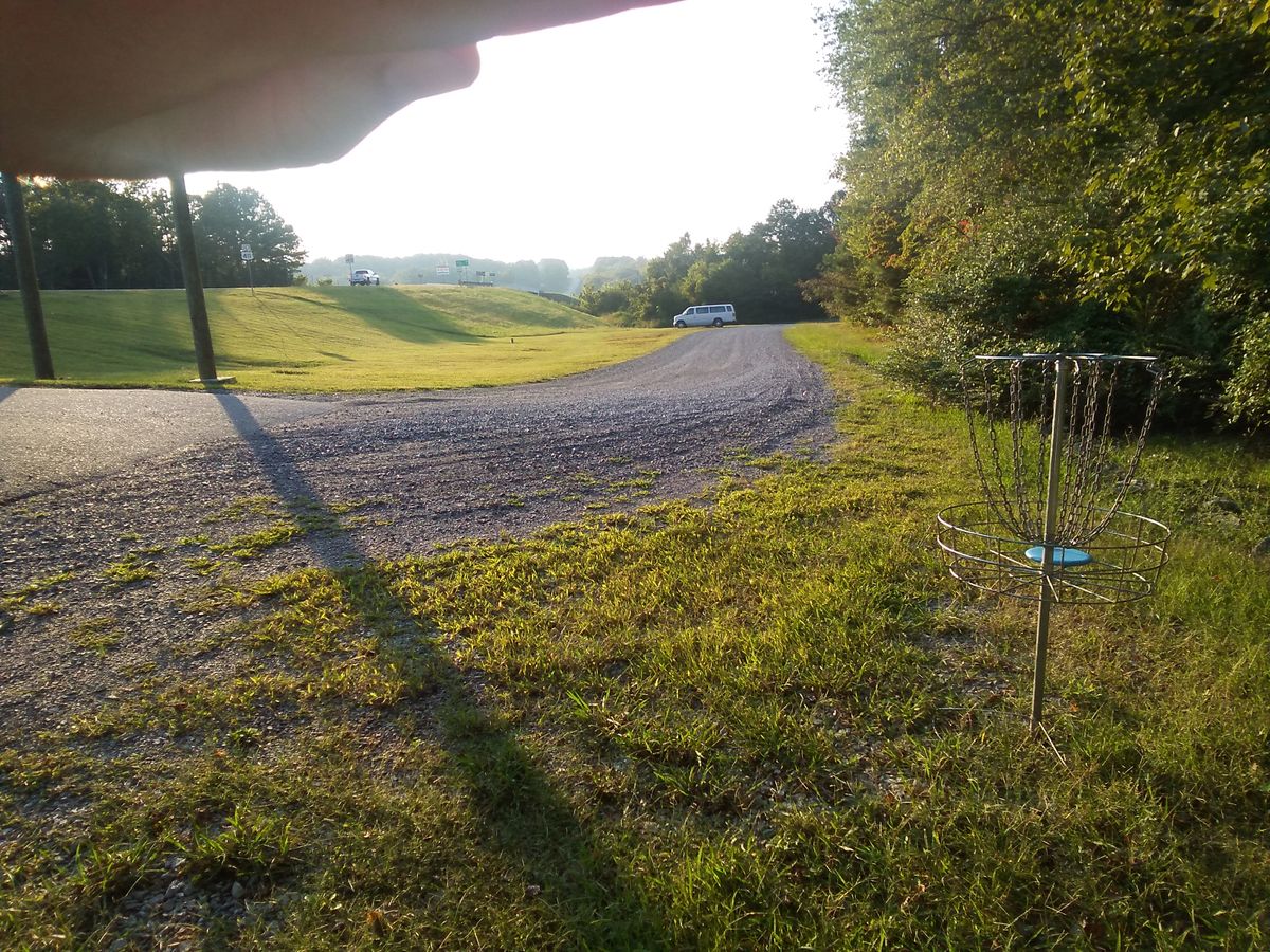 Hole 8 basket looking back at the teepad, gravel road out of bounds