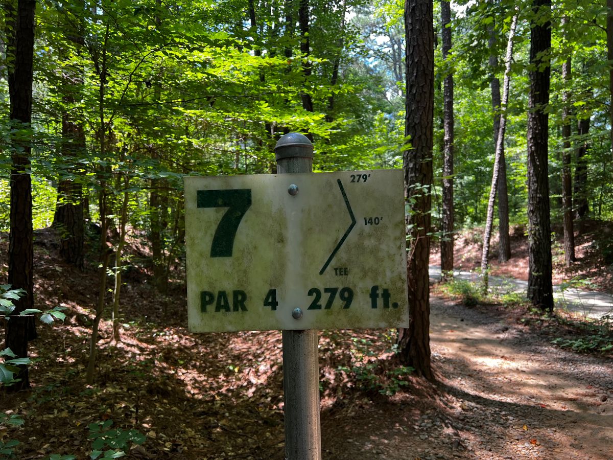 Hole 7 tee sign (hole plays behind you when looking at sign; throw back towards walkway bridge.)