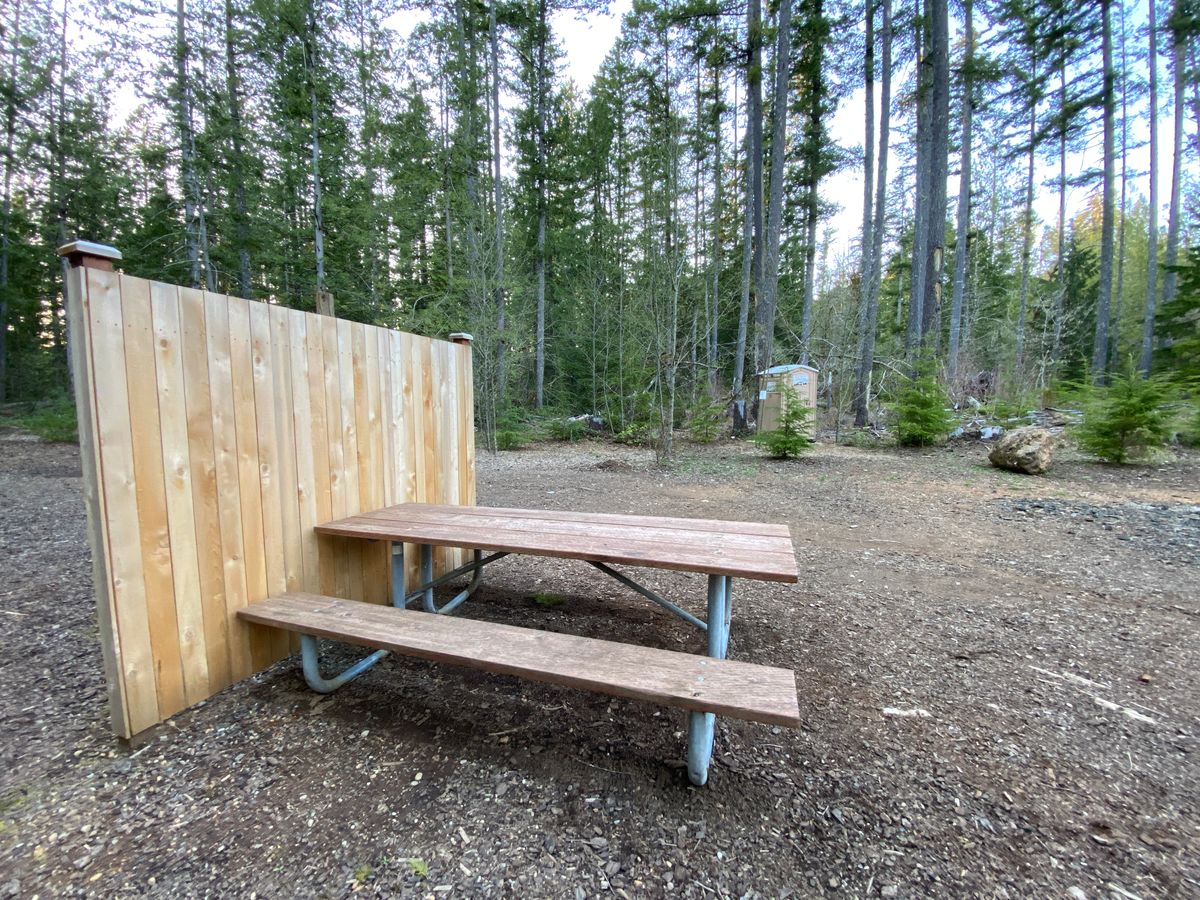Picnic table, portapotty, and practice basket at the parking lot.