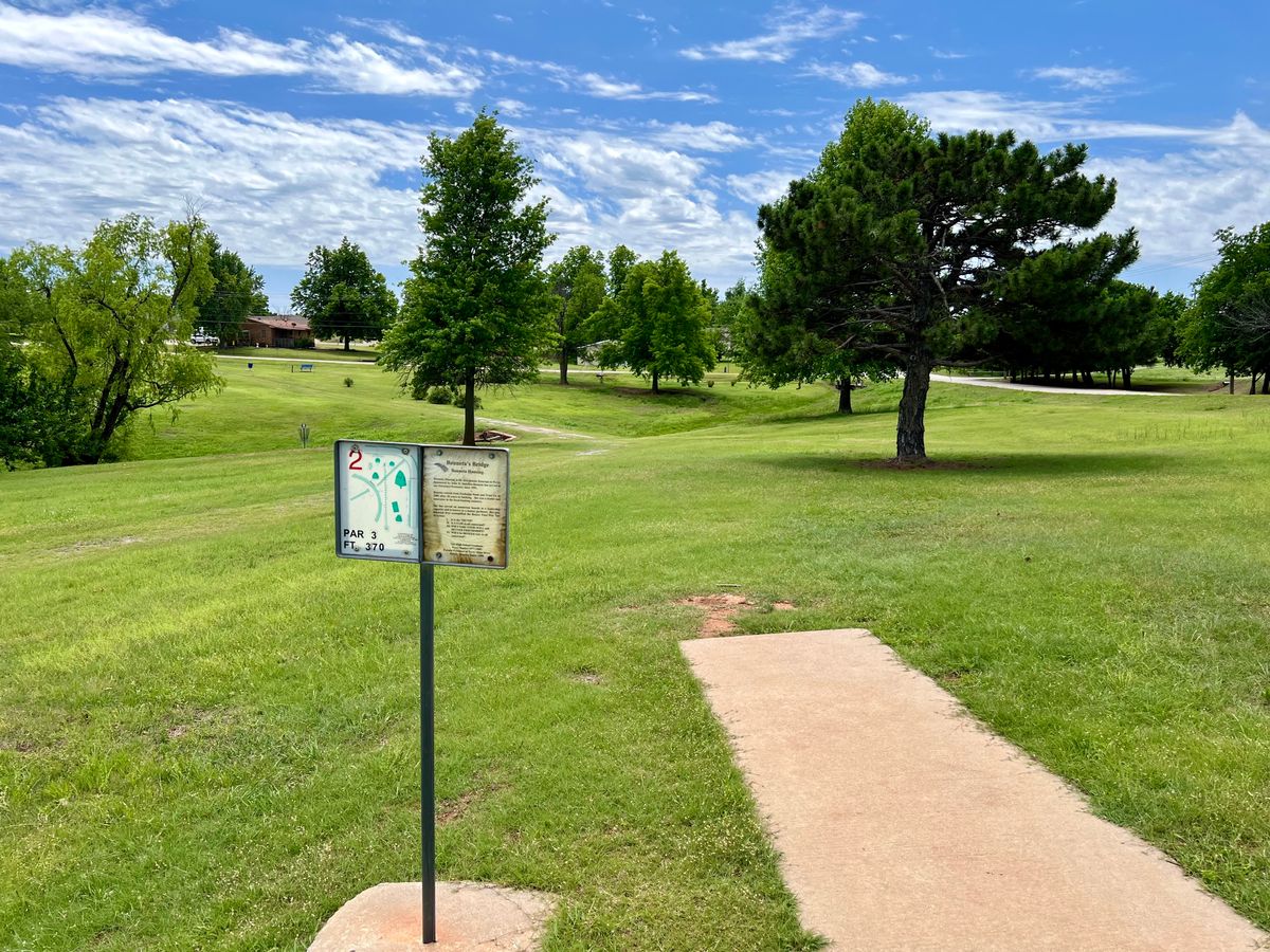 Hole 2. 370 ft par 3 over a creek bed and bridge into some trees.