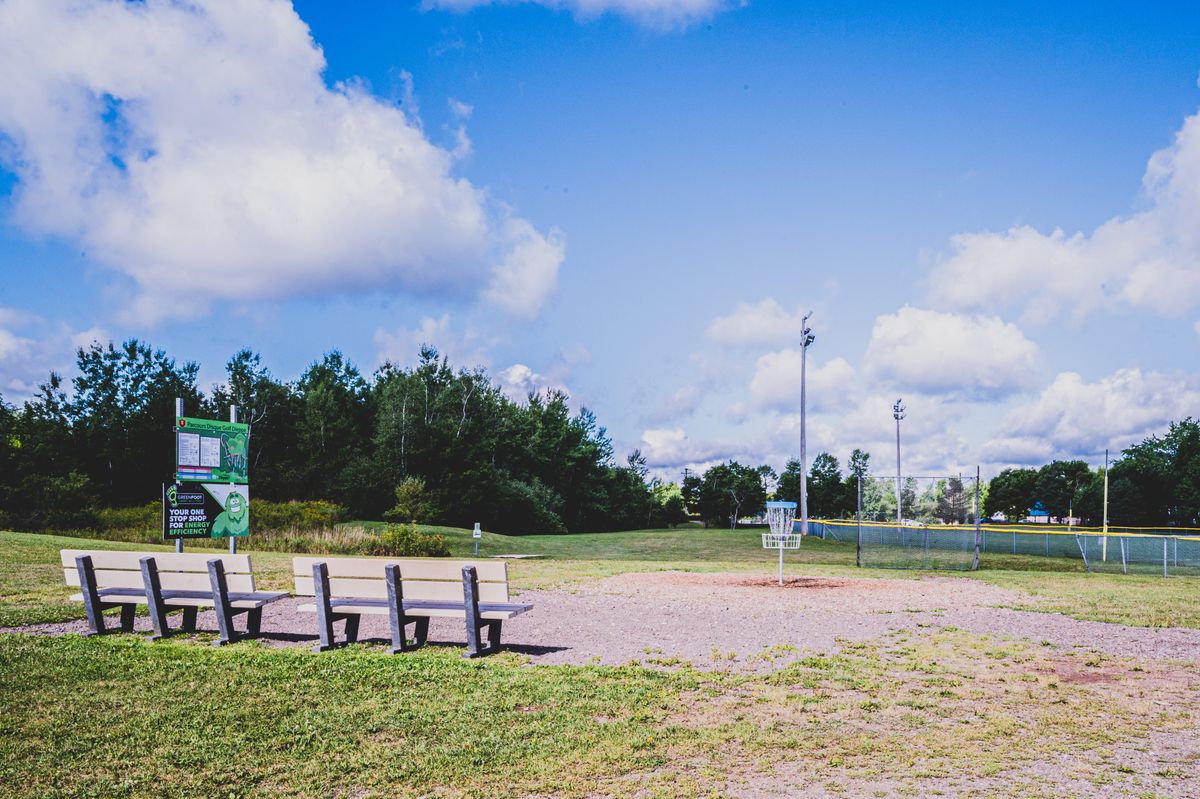 Practice Area with practice basket, throwing net, welcome sign, and benches.