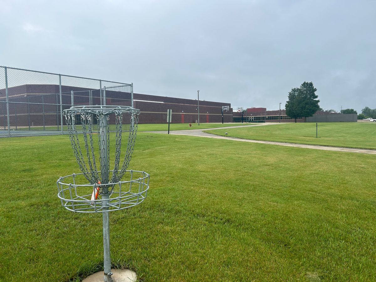 Hole 8 basket with school behind