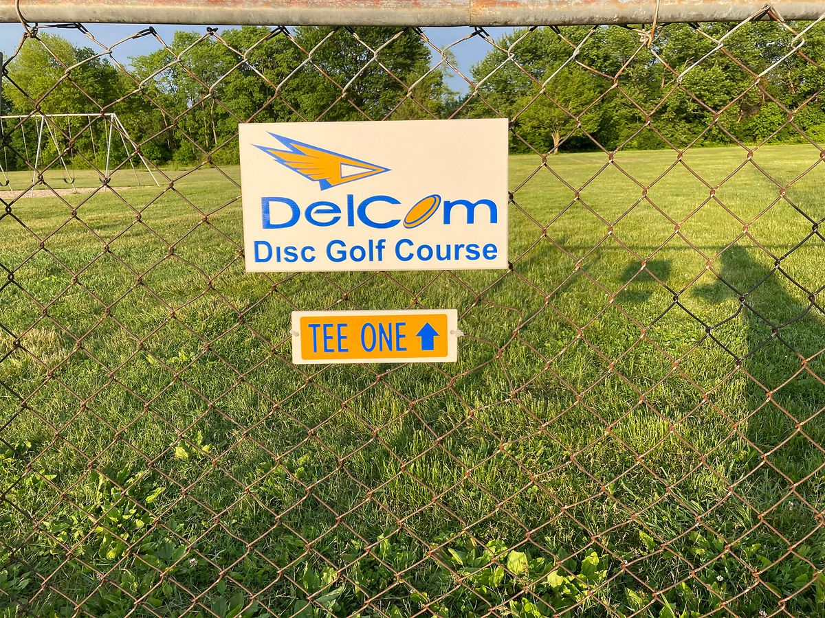 Course sign to start.  Tee pad 1 is to the right of the swing set in the background.