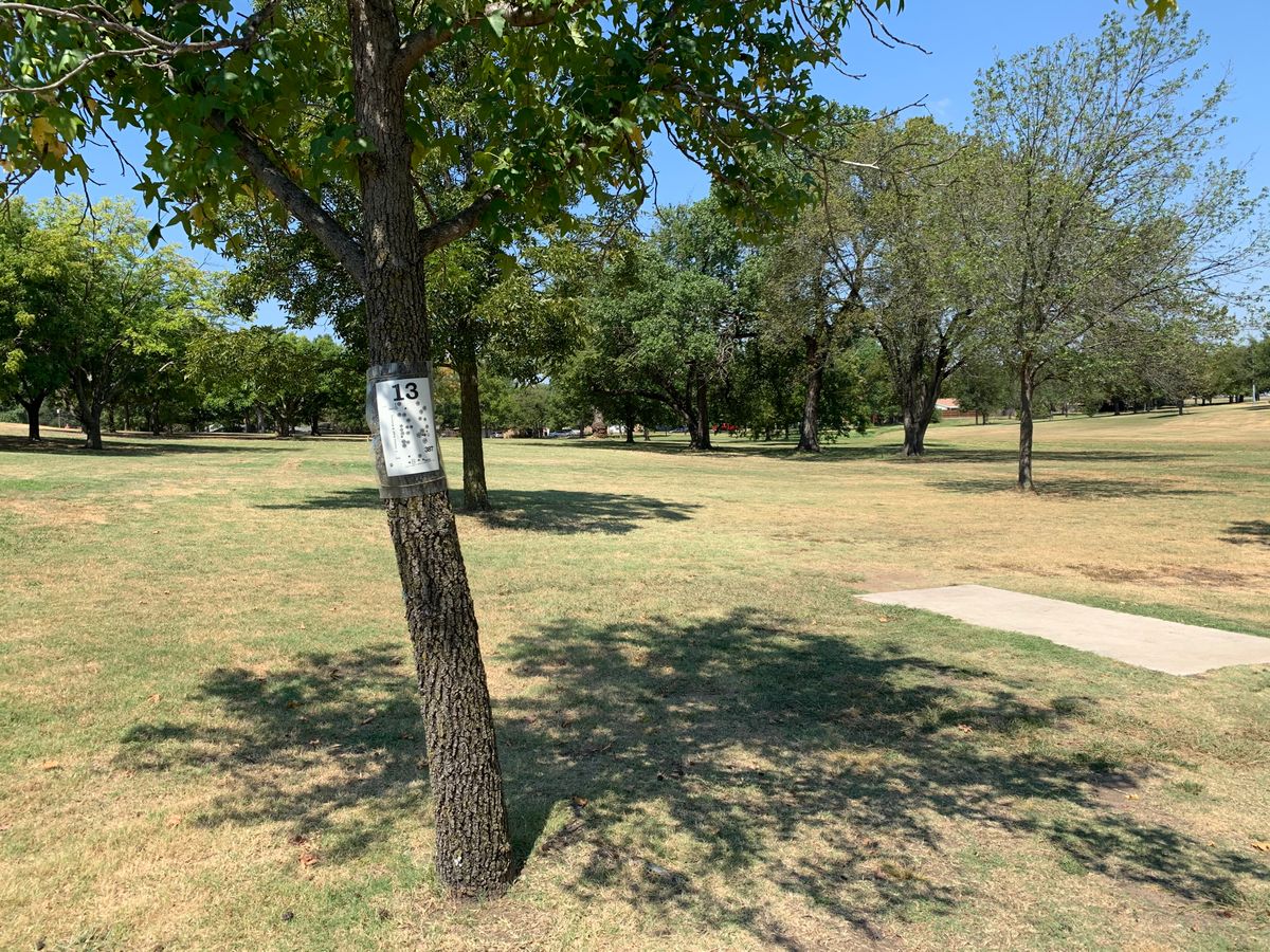Hole 13. Signage on the tree to the left of the tee pad.