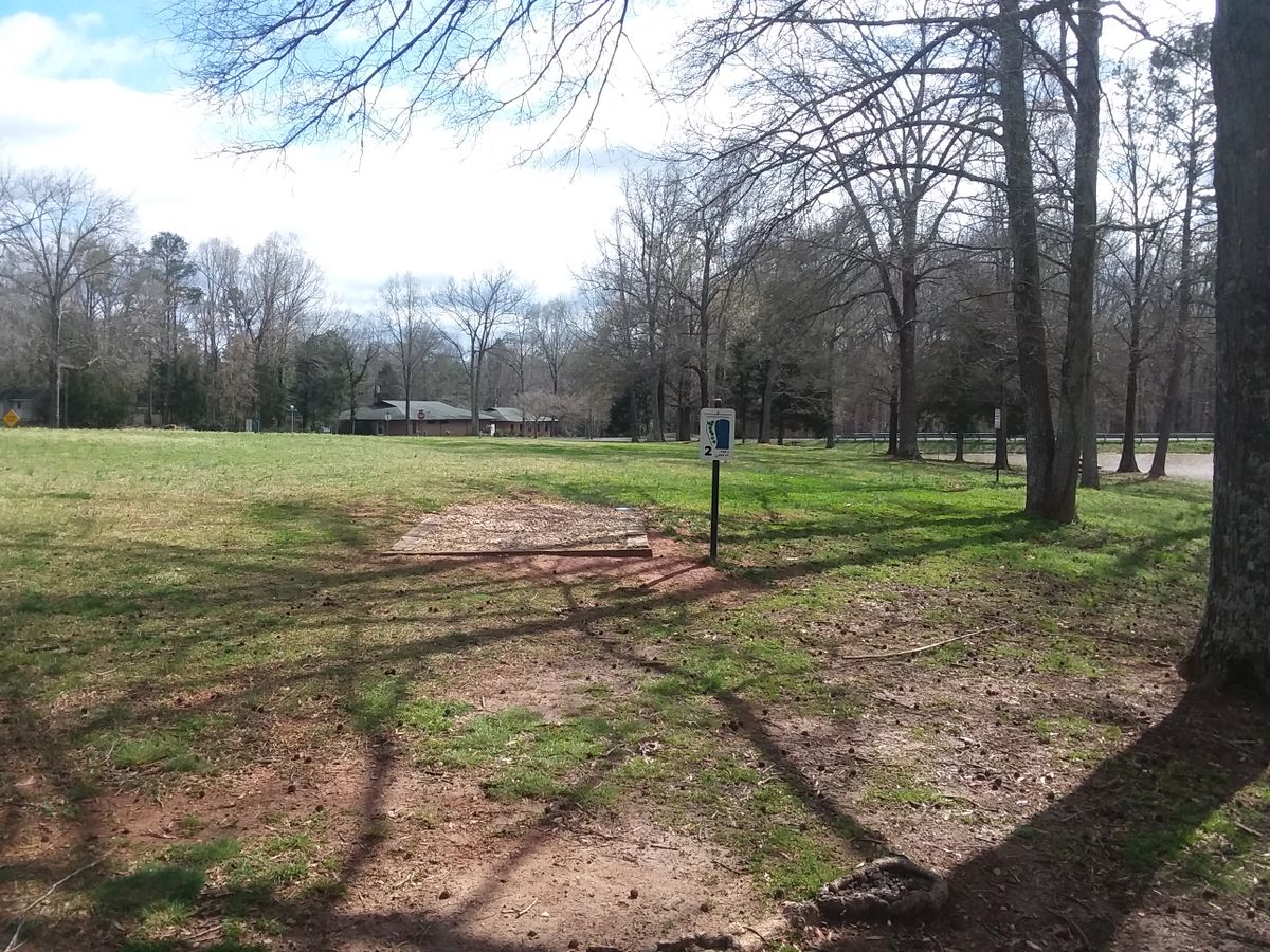 The basket for hole two is nestled behind the trees to the left of the T-box sign.
