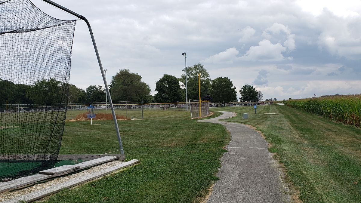 Hole 1 basket. Free drop on sidewalk for shots interfered by batting cage.