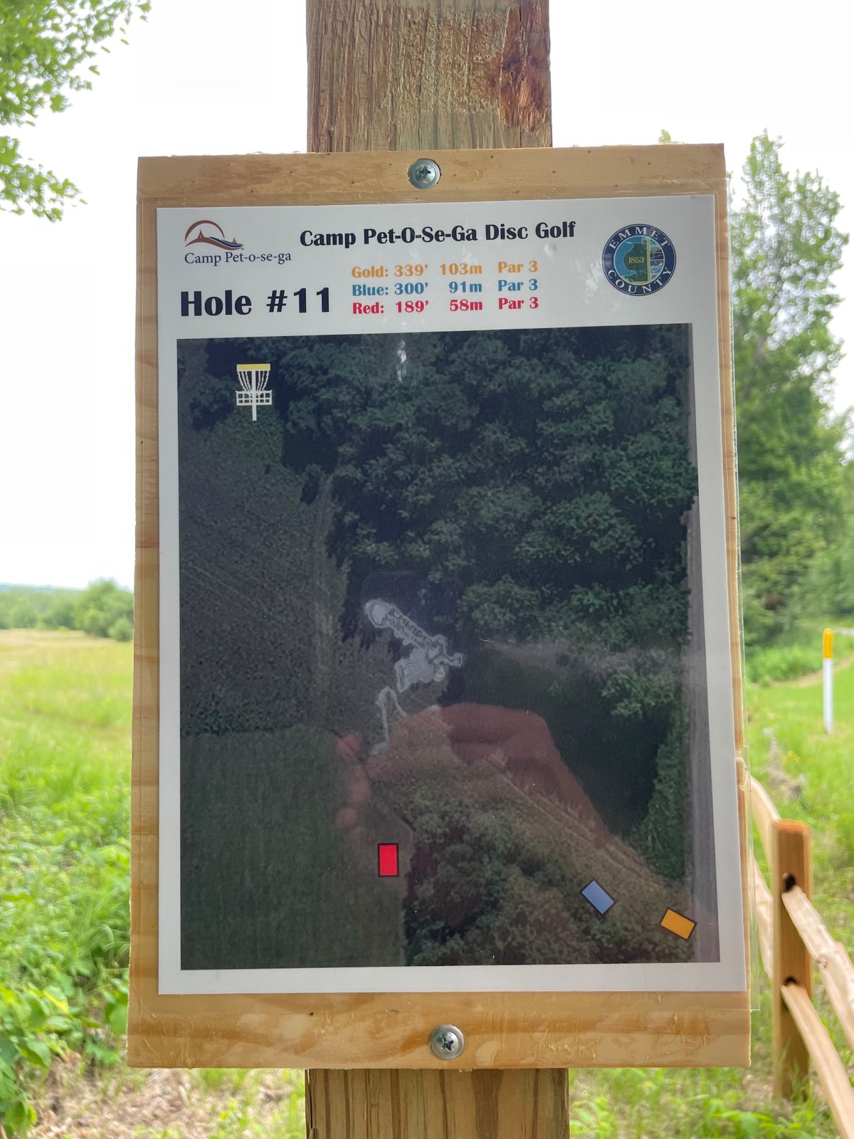Red tee pad to your left (North) on edge of open field