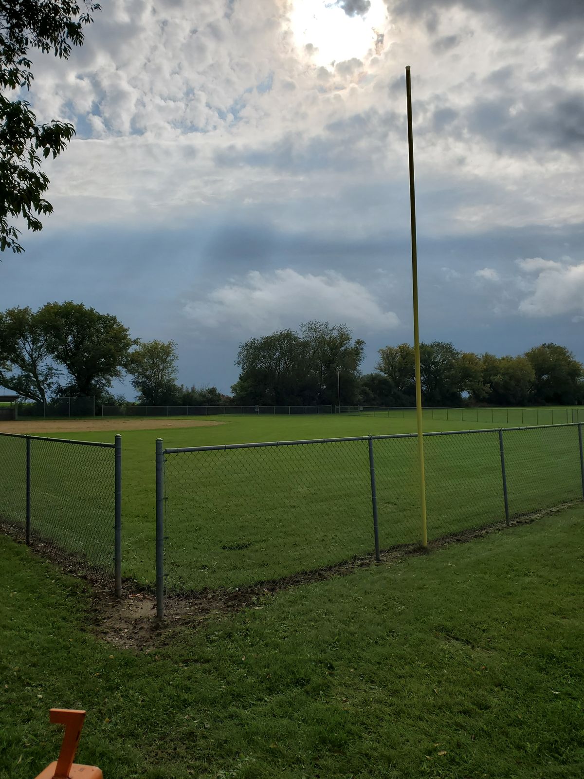 Baseball field OB just left of other foul pole with woods behind. Hardest here