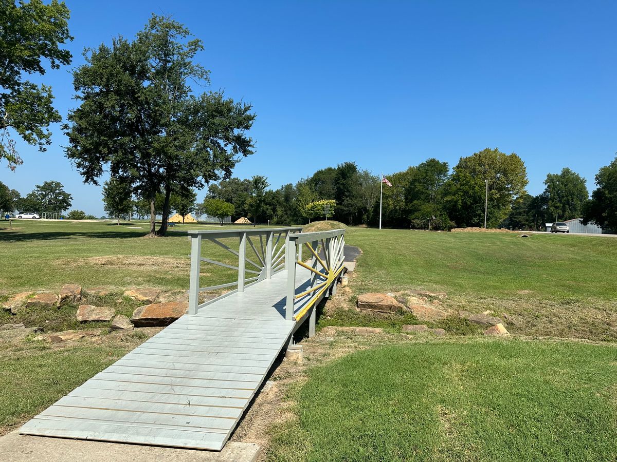 Bridge leading to the 9th hole basket on a hill. Mulberry Arkansas Disc Golf Course.
