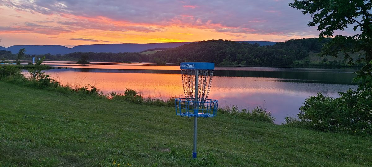 Short pin on hole 18 with sunset in background.