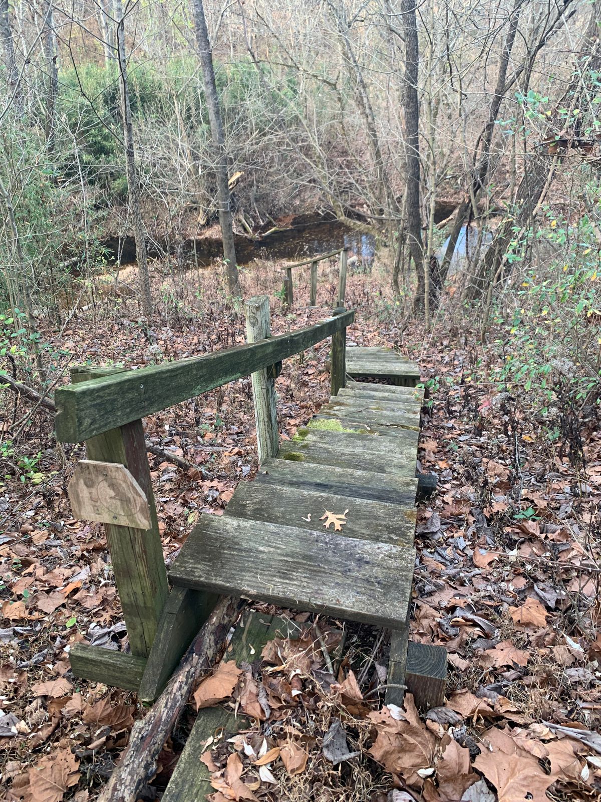 Stairs down to the first tee and a faded “Hole 1” sign.