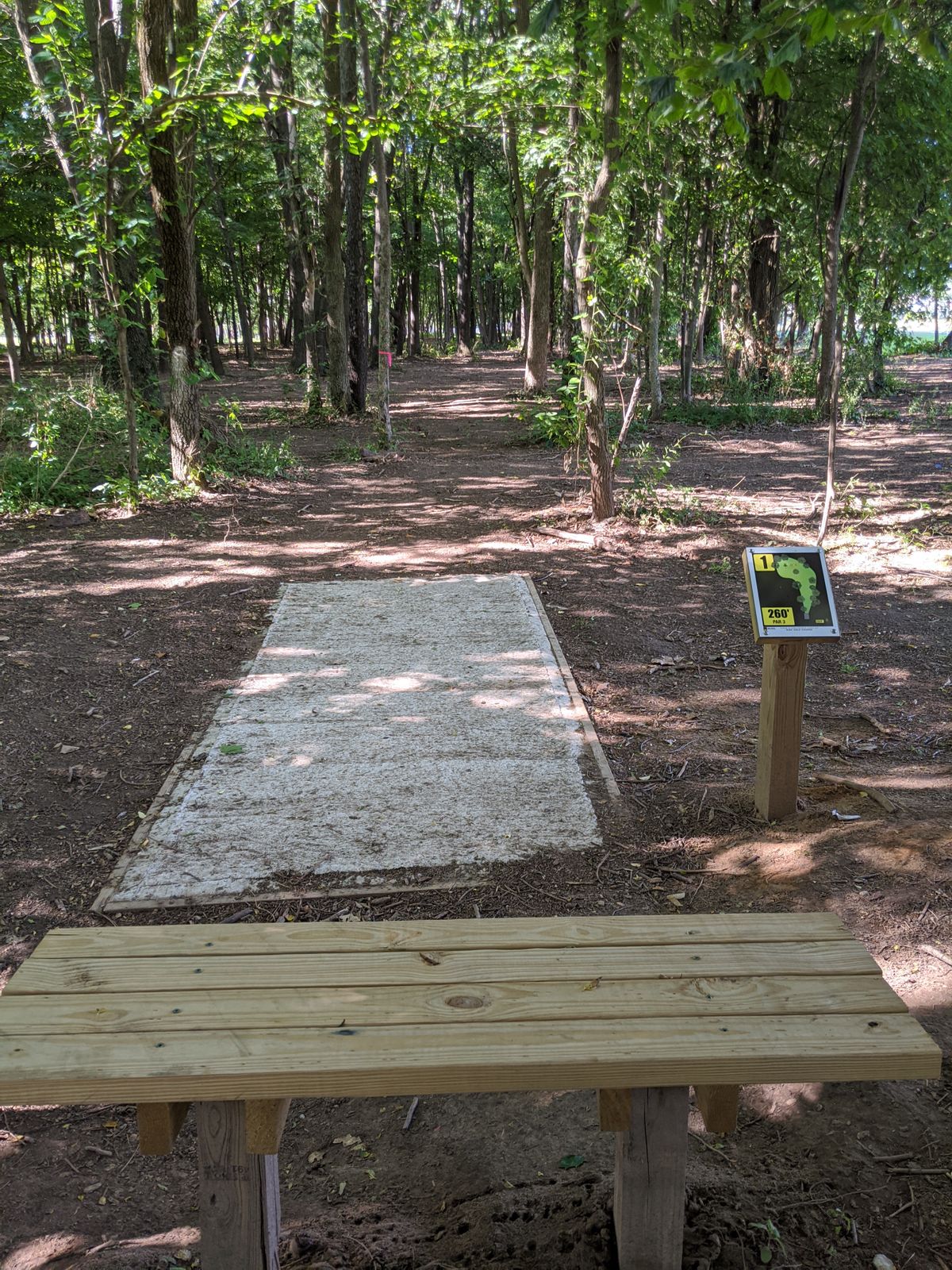 Hole 1 tee box, bench, and sign.