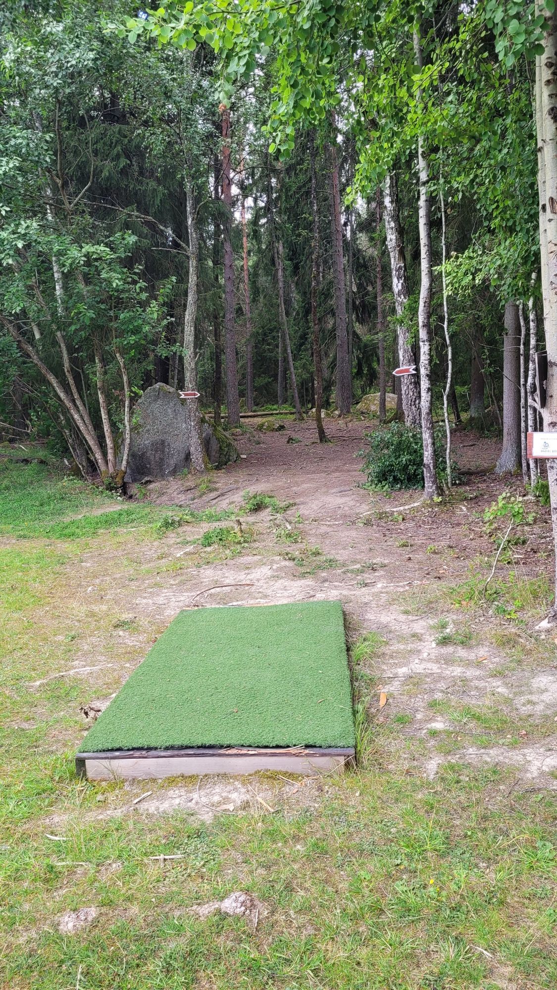Amatör-tee hål 18, och ingången i skogen med dubbelmando