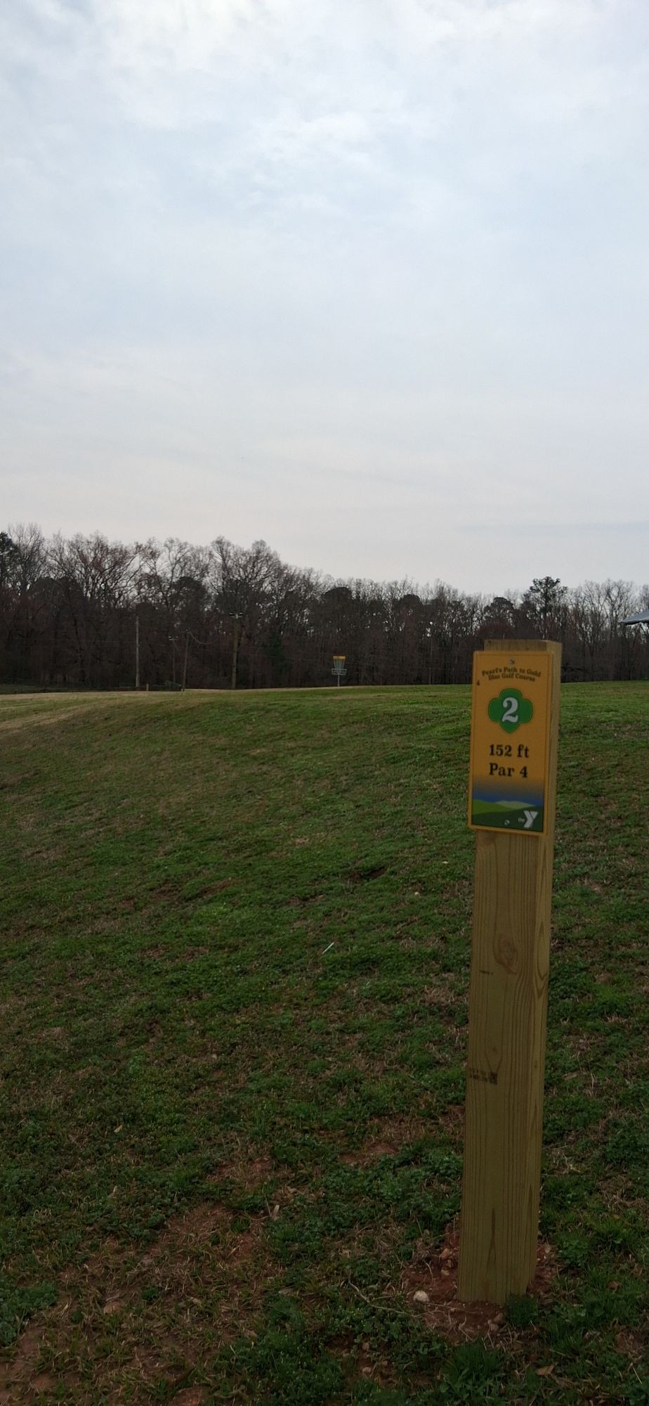 low, uphill tee to green that drops off behind basket