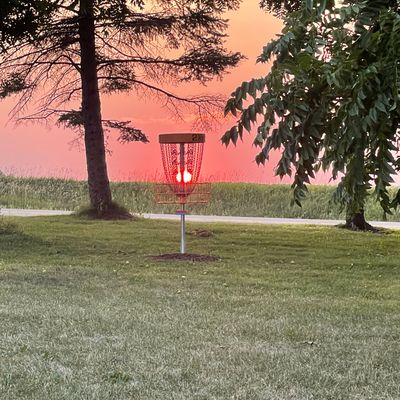 Hole 2 basket by parking lot at sunset 