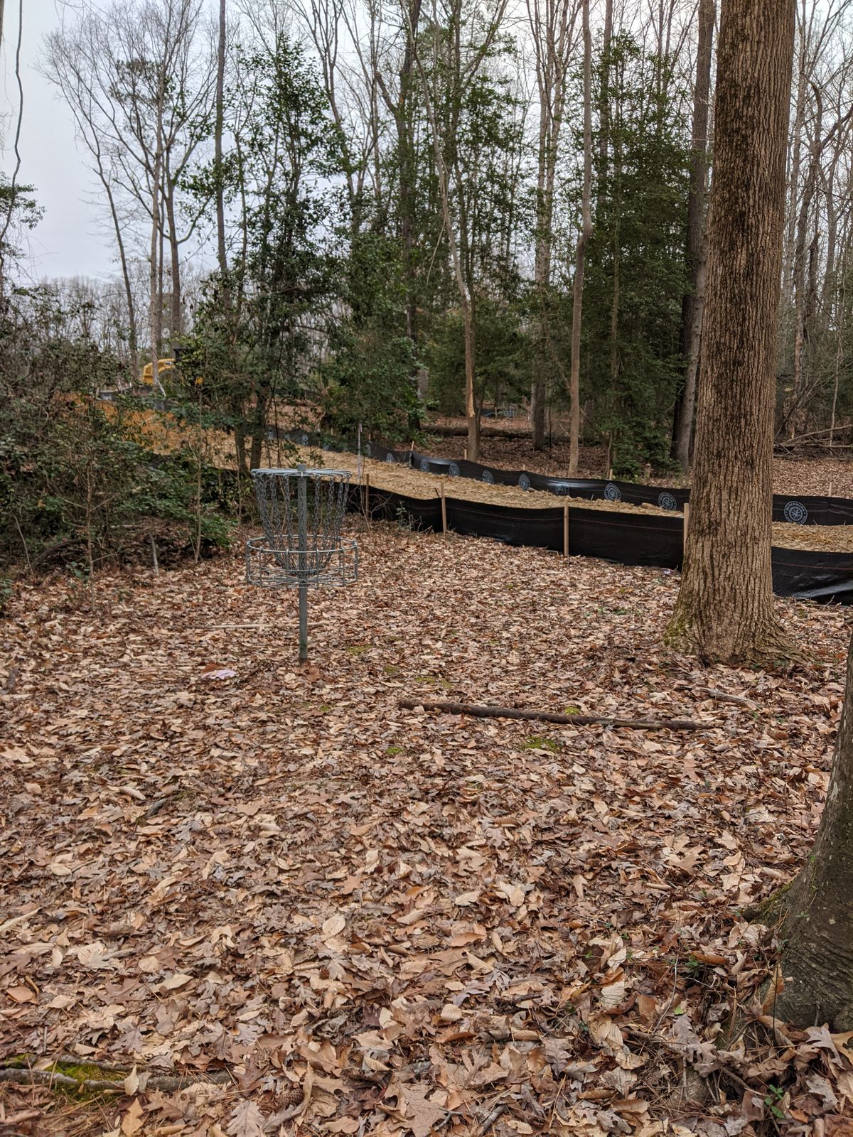 Hole 13 basket looking at 12 basket with construction going through both fairways, still playable