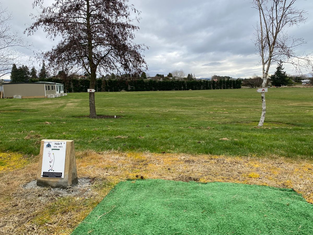 Tee pad 9, looking up the fairway towards the basket. This includes the double mando arrows.