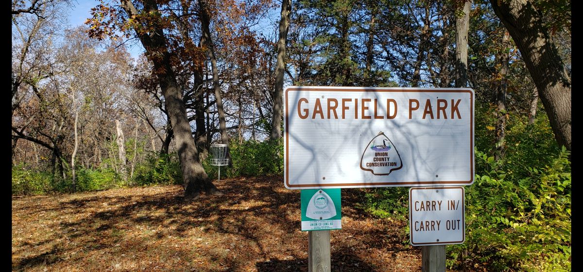 Park sign overlooks hole ones basket.