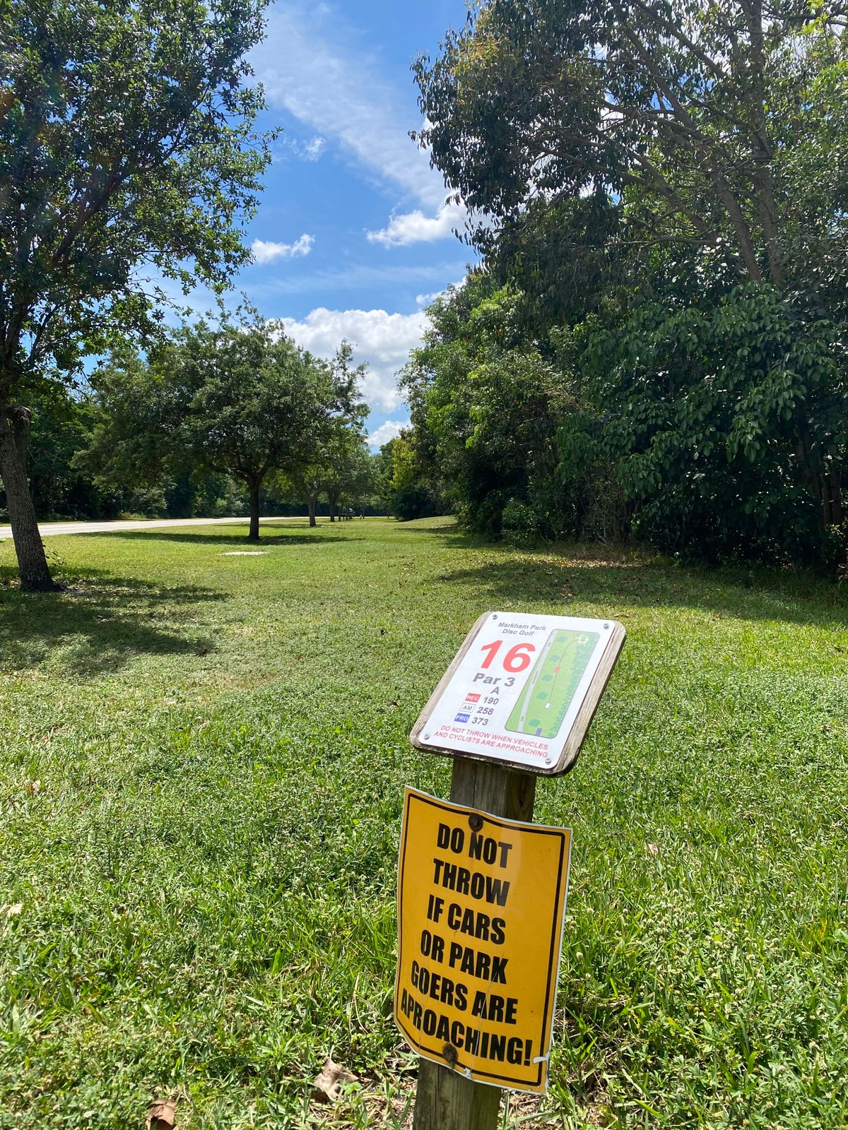 Tee sign at hole 16. Plays up along right side of trees