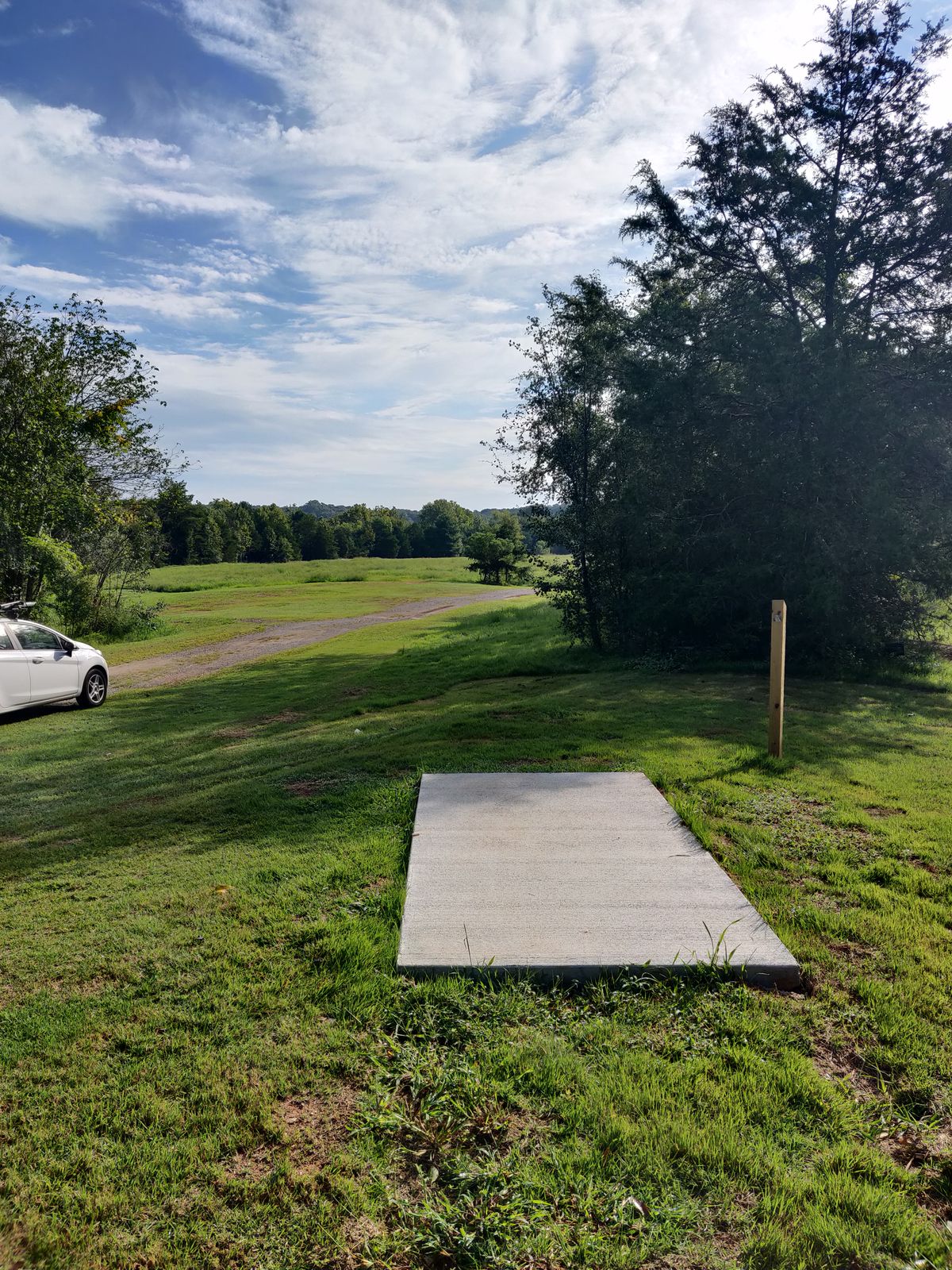 Hole 4 tee pad. Basket is behind the in the middle of the picture. Hole 9 basket is slightly out of frame to the left.