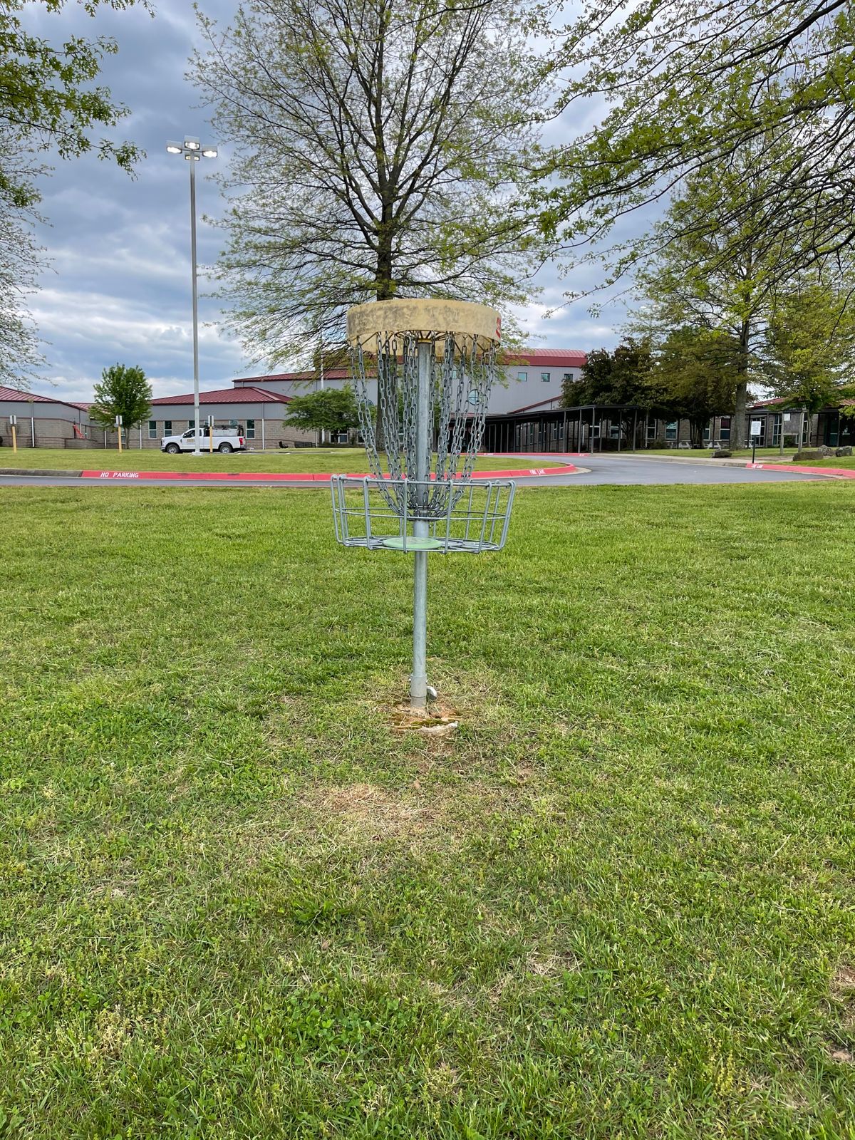 Hole 7 basket- have to throw over a fence - can see pad for 8 near front door of school