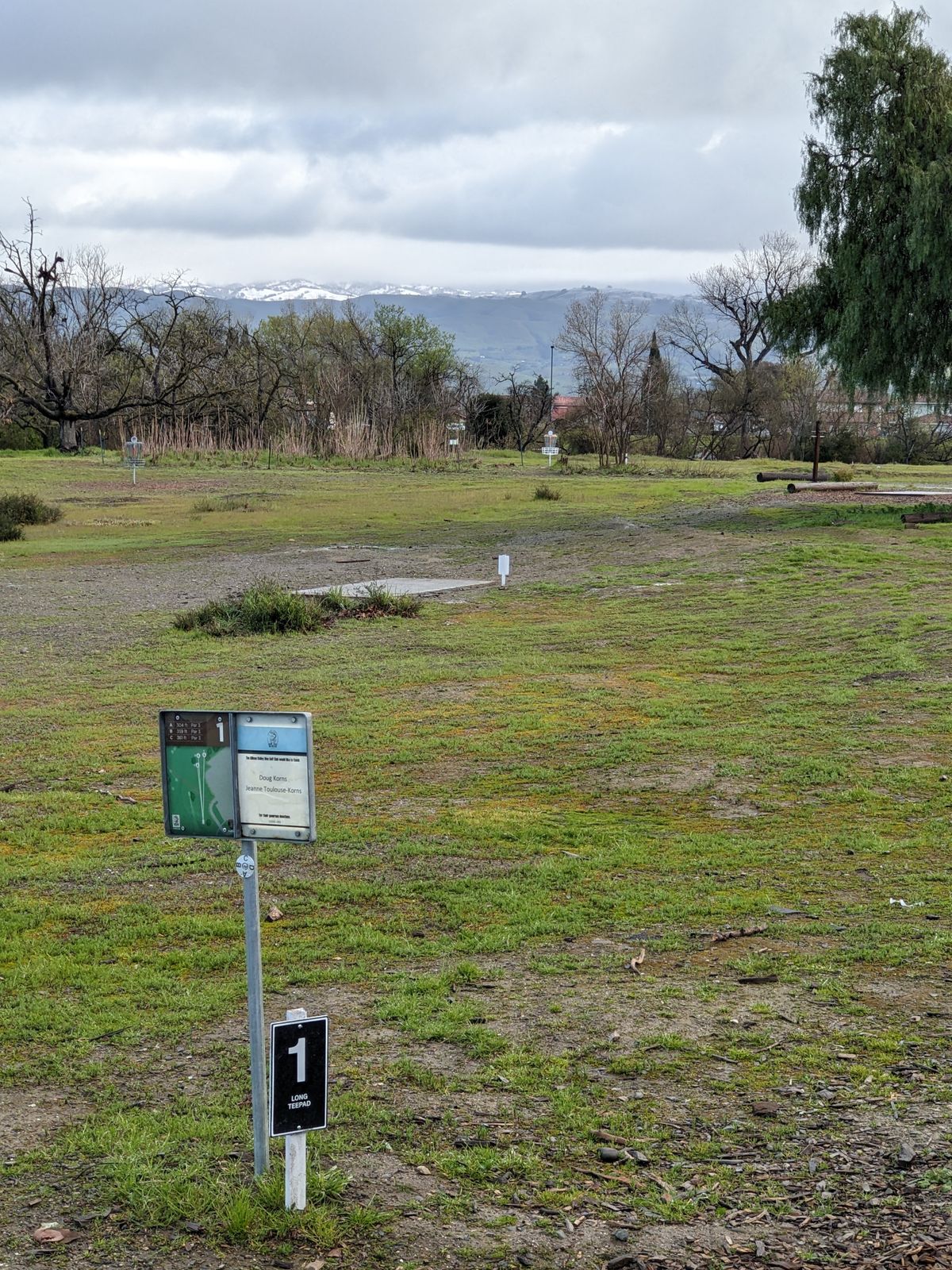 Hole 1 long tee pad with unusual snow capped mountains as a backdrop