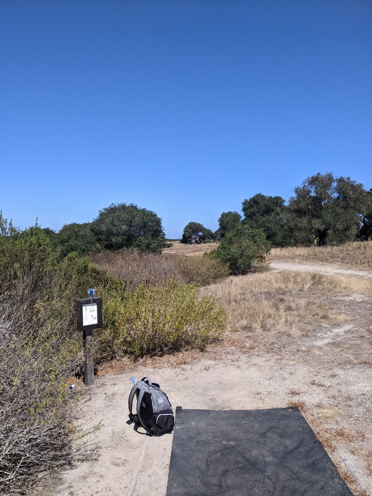 Tee pad. OB is fence/road and beyond the entire left side accompanied by a massive hillside. This hole can also be played as Par 4 and Par 5 to 8a's basket.