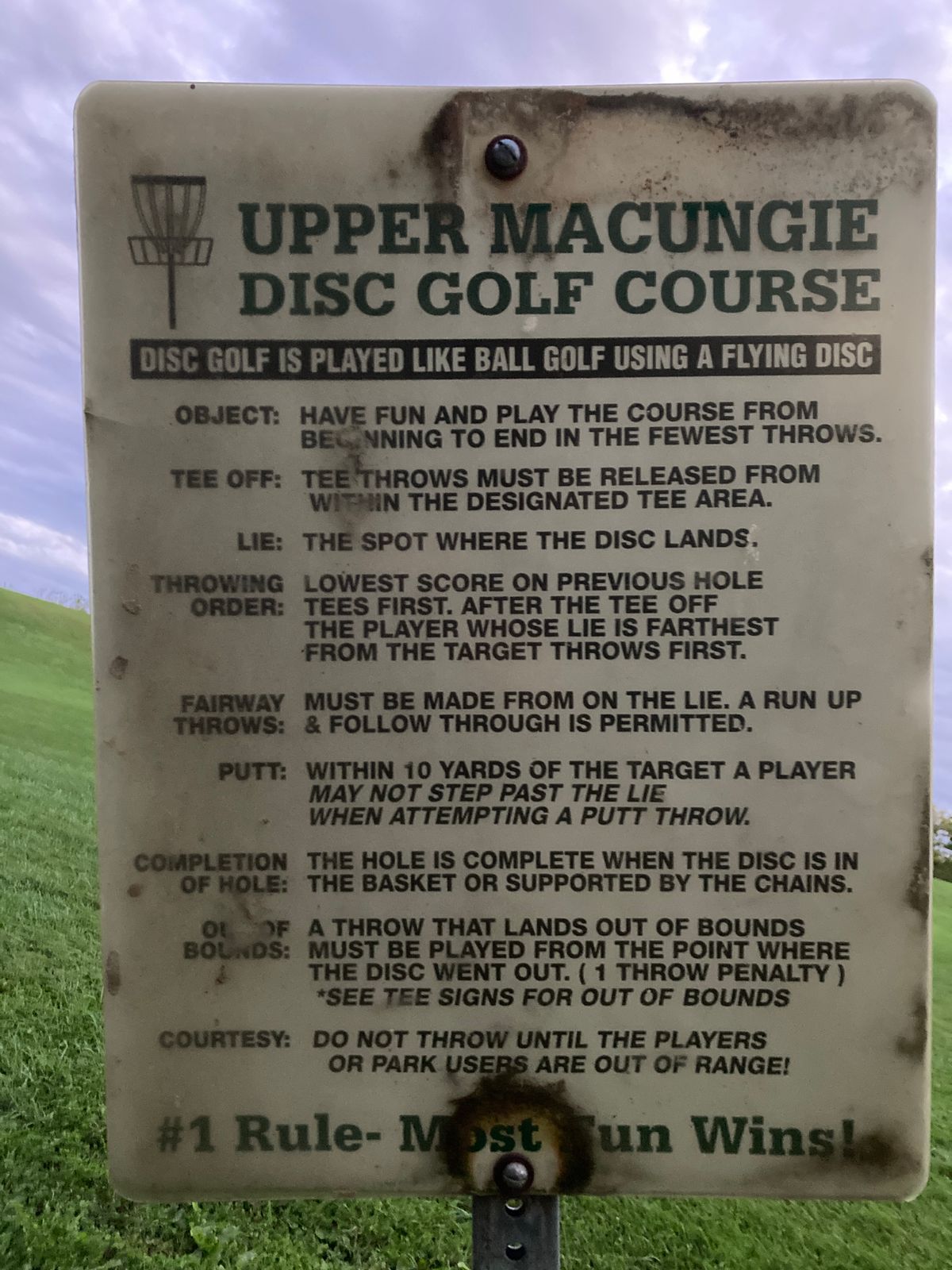 Rules sign. Hole one towards the right near white fence.