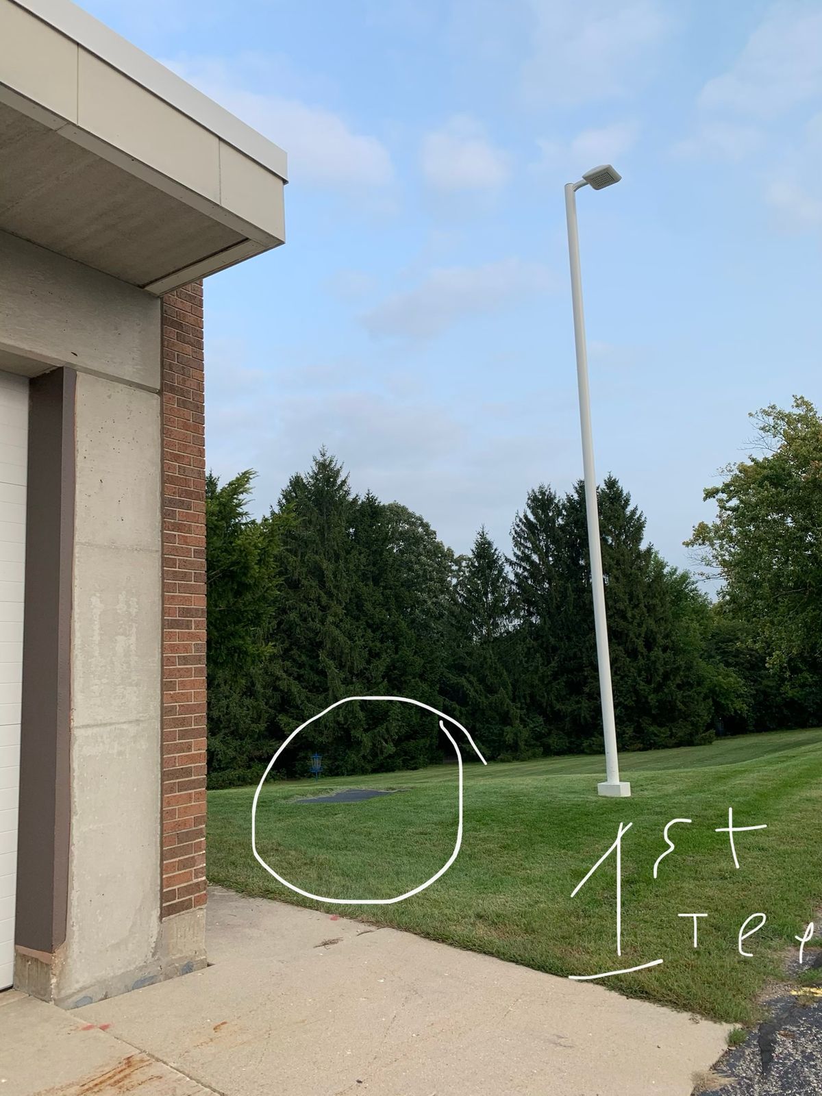 First tee- look for light pole next to four car garage building