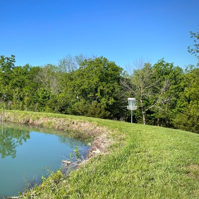 Hole 6 basket sits along the side of the pond dam.