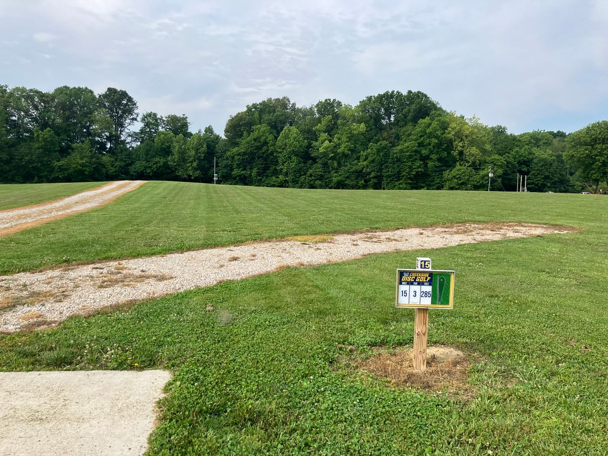 Hole 15 plays to an elevated basket. 275’ basket is adjacent to a roll away hill. Gravel plays OB.