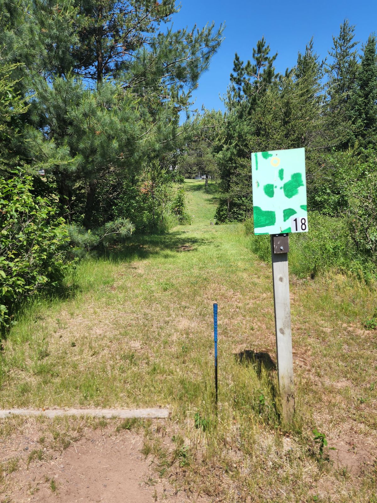 Hole 18 Overview. Good shot is dead strait landing past small trunk tree in the distance on the right side of elevated terrain.