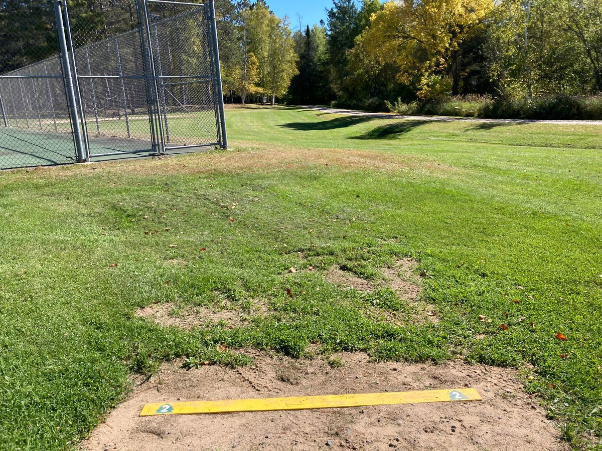 The Hole 2 tee marker offers a challenging shot around the tennis court.