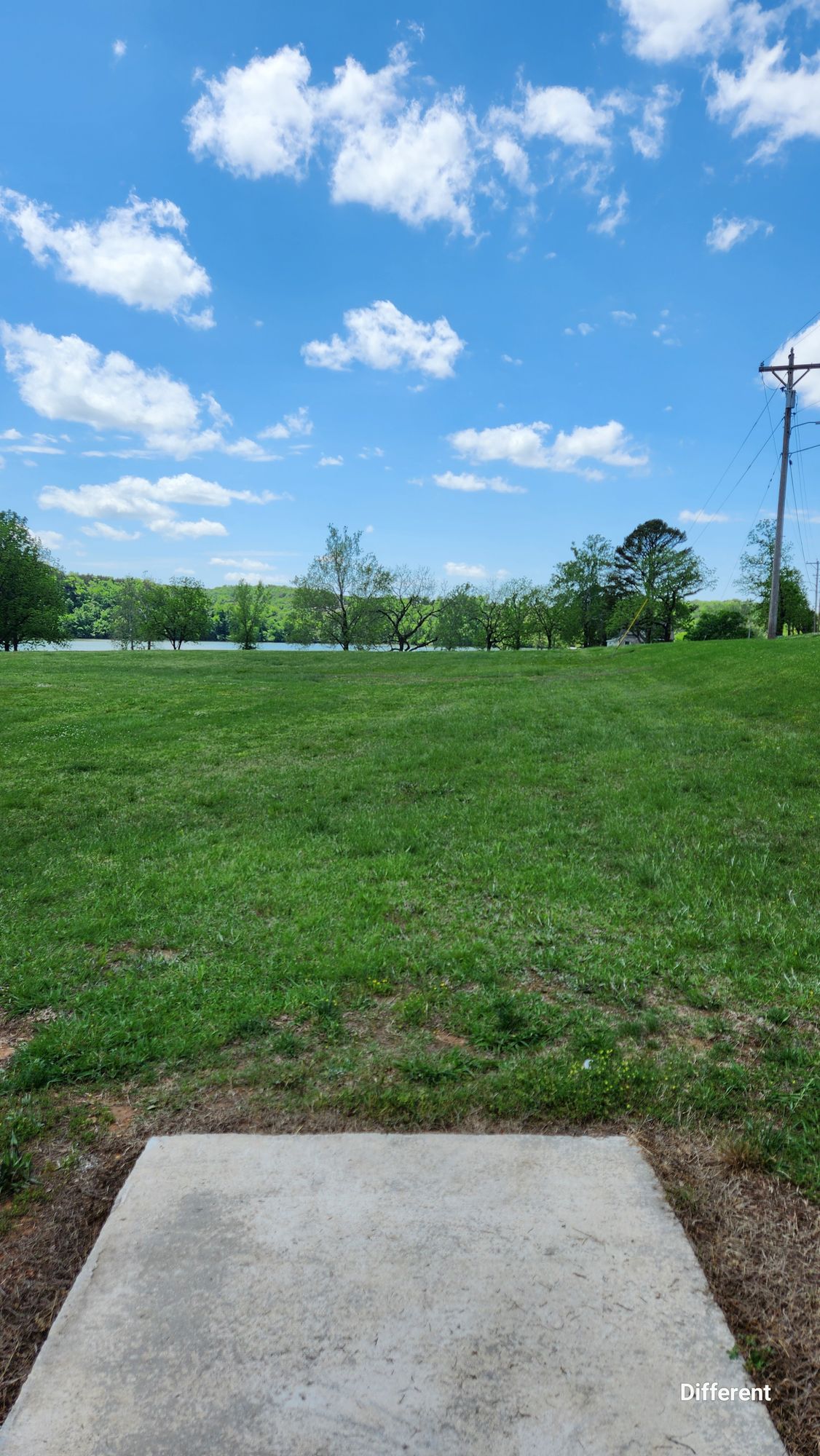 Hole 17. Fairway slopes away faster as it gets closer to the basket, which isn't visible from the tee. It is just out of sight over the ground line, pretty straight in front of the tee. 