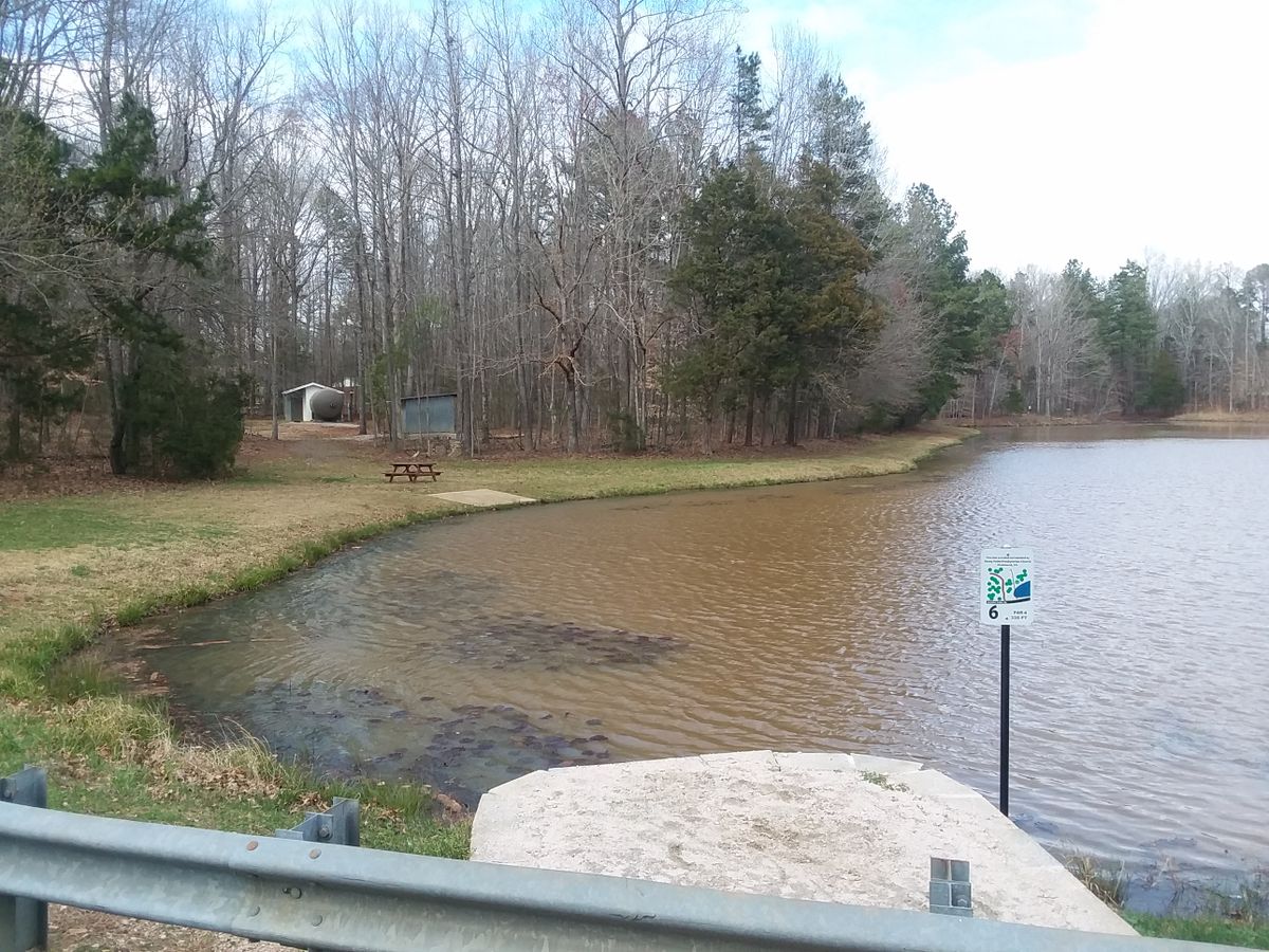 Across the water, the basket for hole 6 is behind the tank.